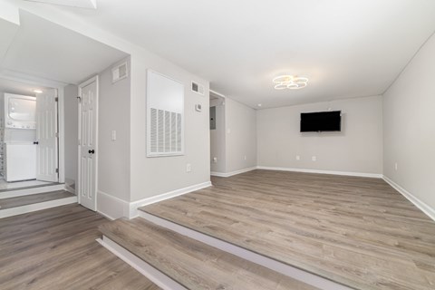 A spacious living room with a television and hardwood flooring.