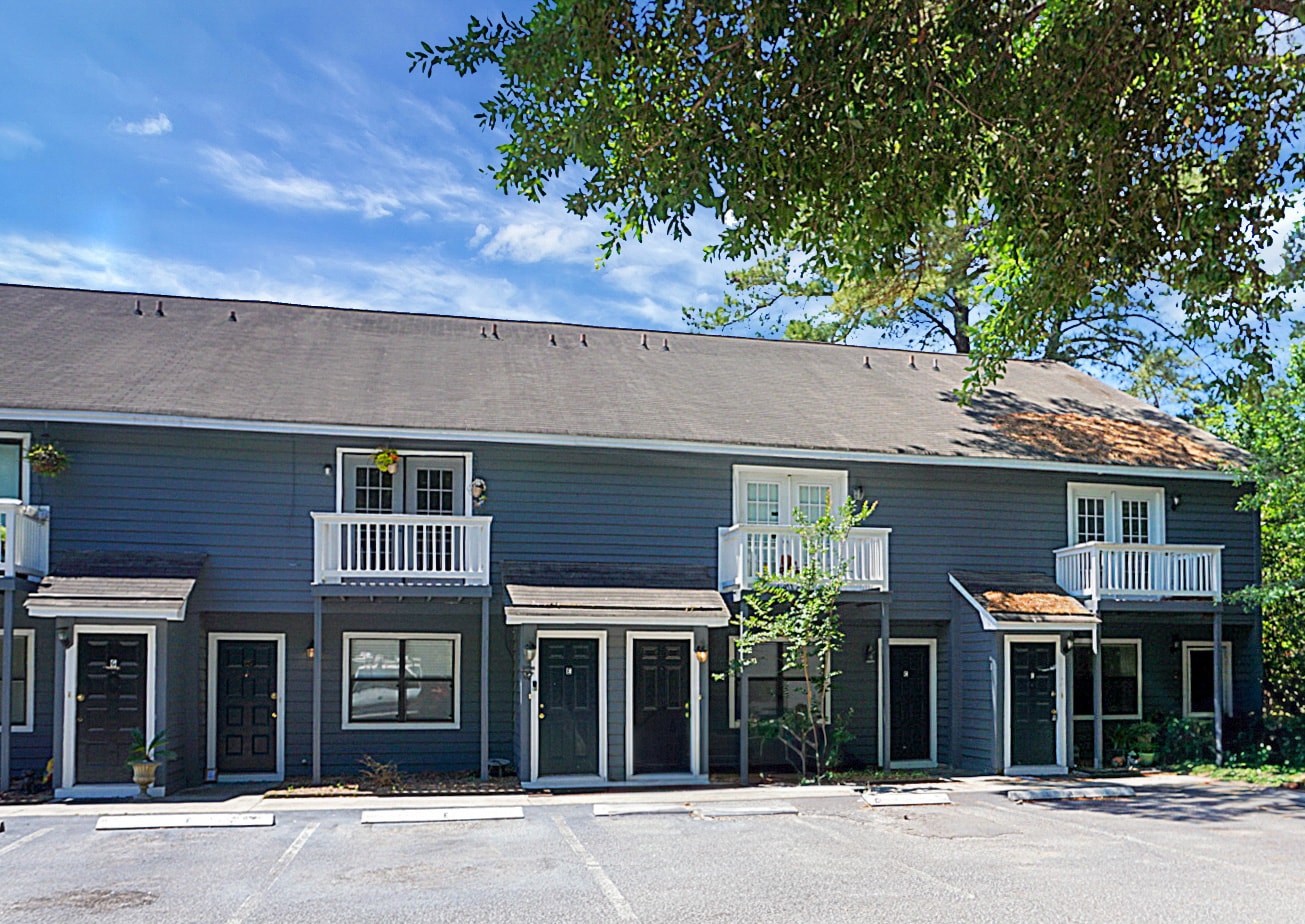 A row of townhouses with balconies and doors.