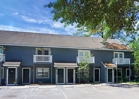 A row of townhouses with balconies and doors.