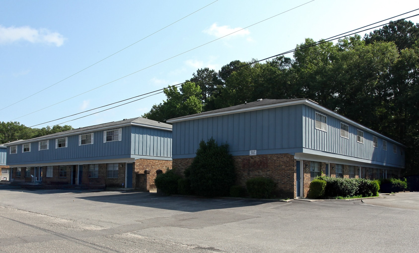 A large industrial building with a parking lot in front.