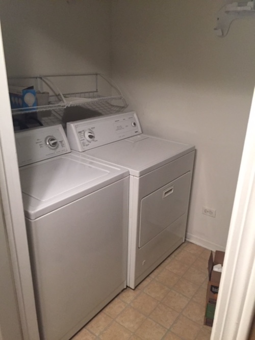 A white dryer and washer in a small laundry room.