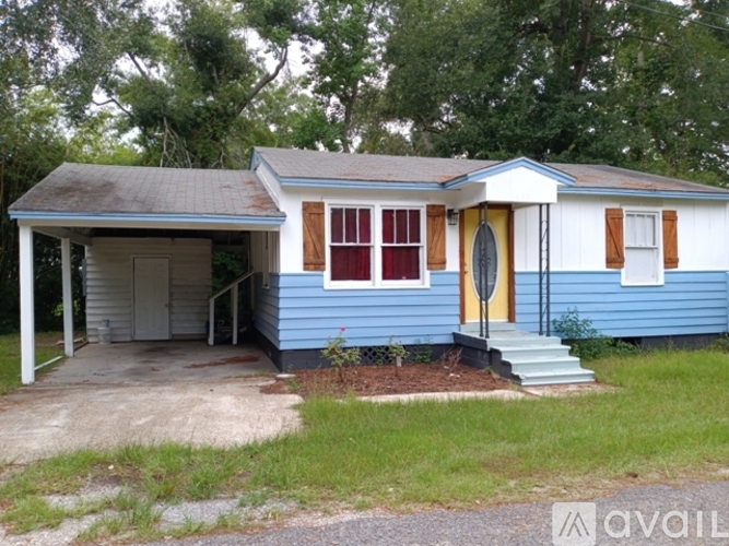 A blue house with a yellow door and a porch.