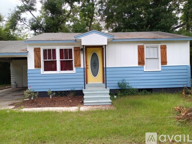 A blue house with a yellow door and brown shutters.
