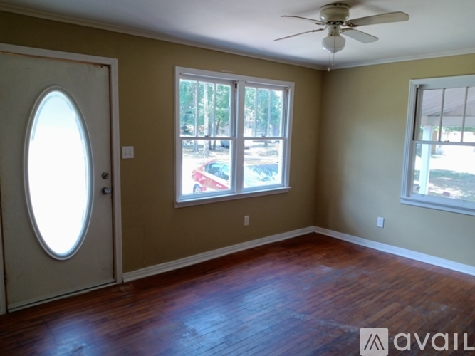 A room with a wooden floor and a ceiling fan.