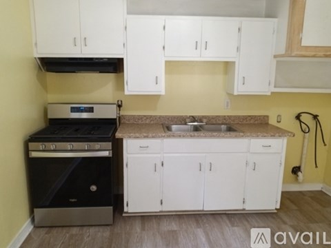 A kitchen with white cabinets and a black stove top oven.