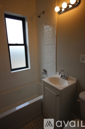 A bathroom with a sink, mirror, and a window.