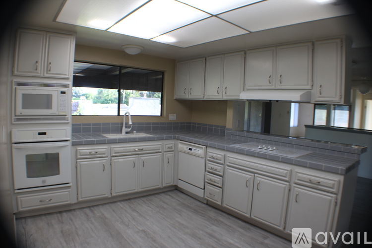 A kitchen with white cabinets and appliances.