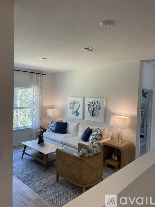 A living room with a white couch and two lamps.