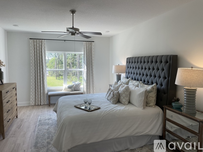 A bedroom with a large bed and a ceiling fan.