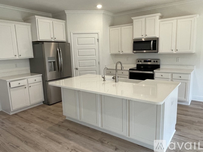 A kitchen with white cabinets and a white island.