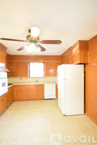 A kitchen with a white refrigerator and wooden cabinets.