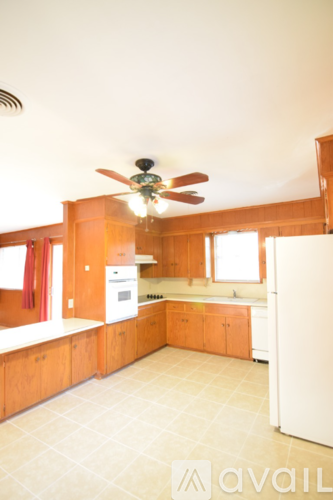 A kitchen with wooden cabinets and a white refrigerator.