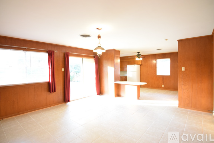 A large empty room with wooden walls and a bench.