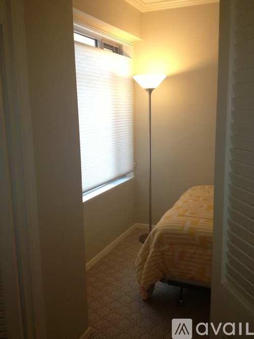 A lamp is on a stand in a bedroom.