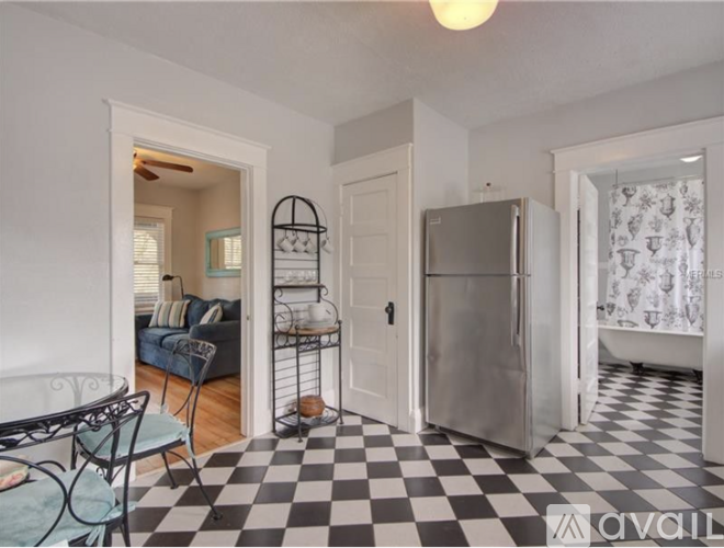 A kitchen with a checkered floor and a refrigerator.