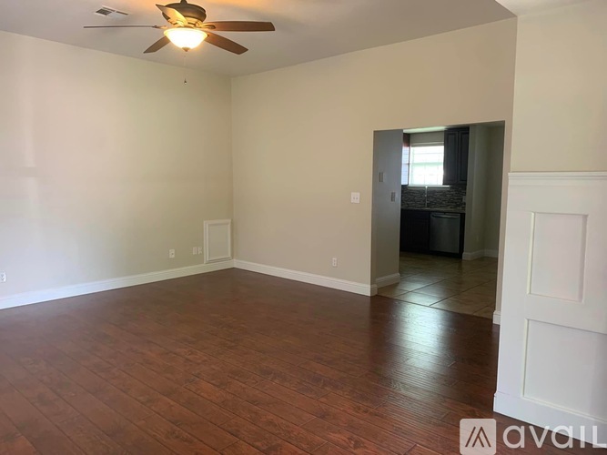 A room with a ceiling fan and wooden flooring.