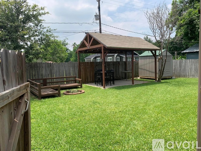 A backyard with a wooden fence and a gazebo.