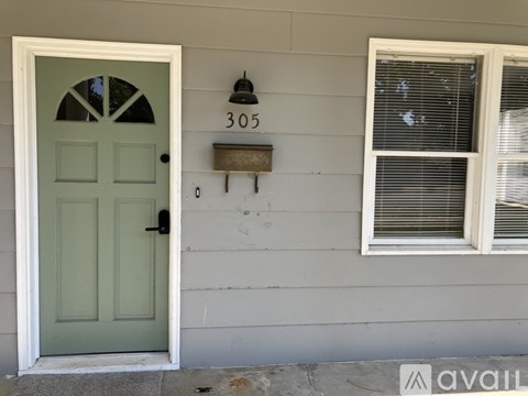 A green door with a number 305 on the wall above it.