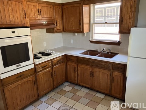 A kitchen with wooden cabinets and a white refrigerator.
