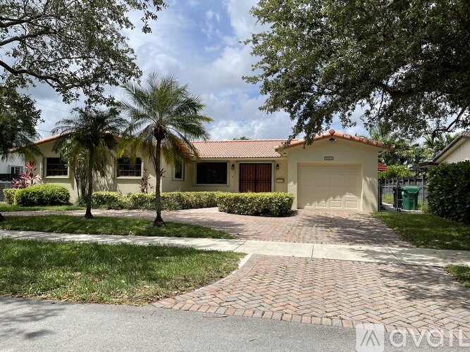 A house with a red tiled roof and a driveway in front.