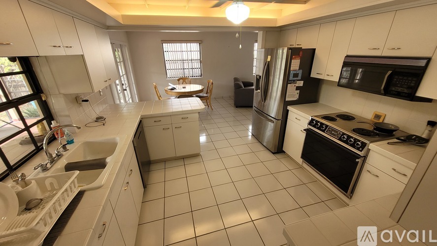 A kitchen with white cabinets and appliances.