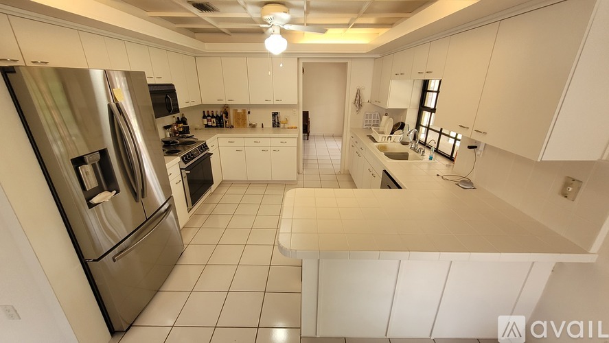 A kitchen with white cabinets and a stainless steel refrigerator.