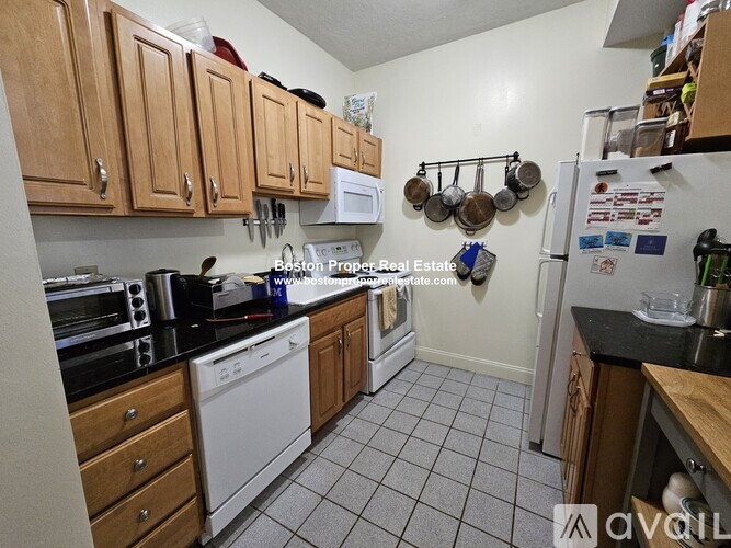 A kitchen with white appliances and wooden cabinets.
