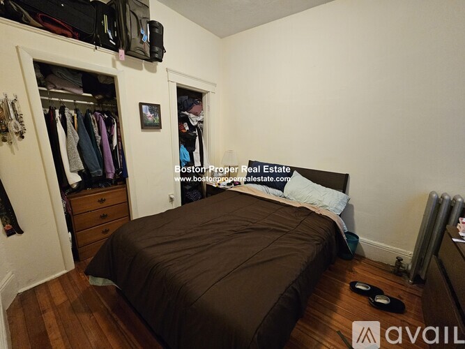 A bedroom with a bed, a dresser, and a wardrobe.