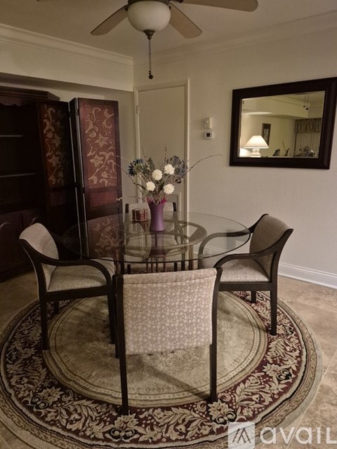 A dining room with a glass table and chairs.