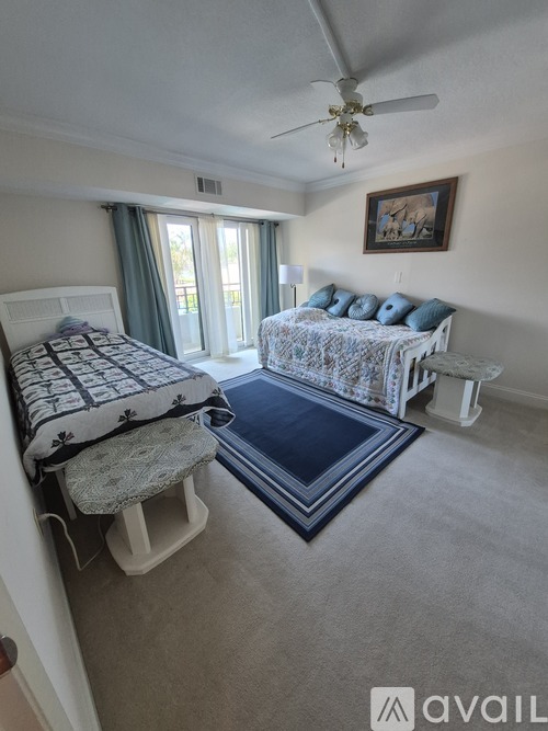 A bedroom with two beds and a ceiling fan.