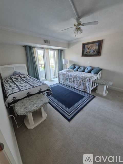 A bedroom with two beds and a ceiling fan.