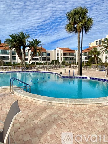 A pool surrounded by palm trees and chairs.