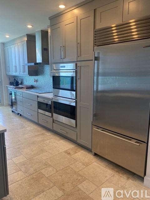 A kitchen with a refrigerator, oven, and microwave.