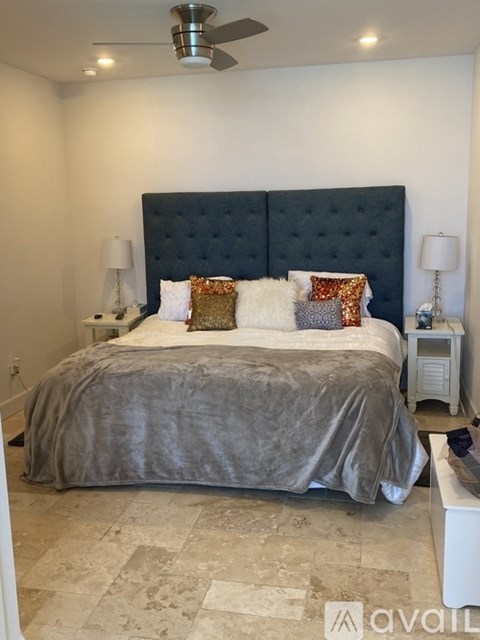 A bedroom with a large bed and a ceiling fan.