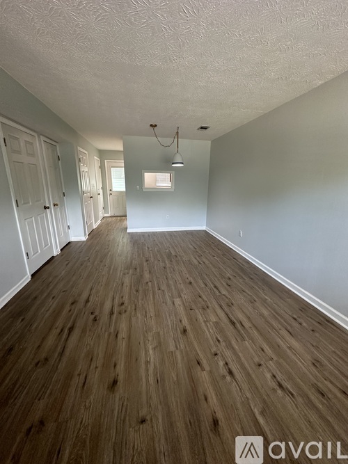 A room with wooden flooring and white walls.