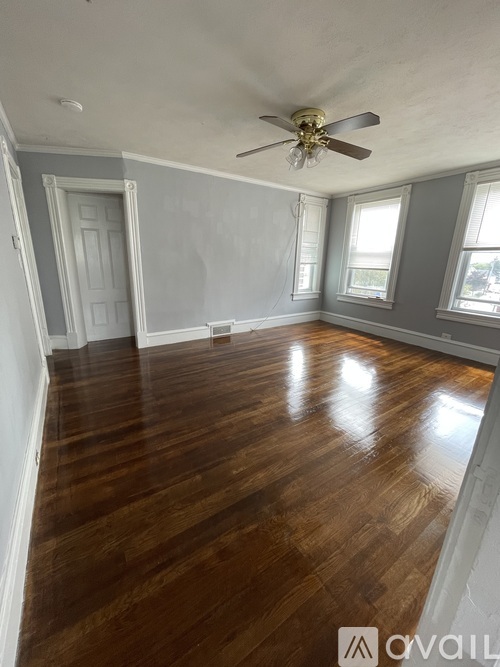 A room with wooden floors and a ceiling fan.