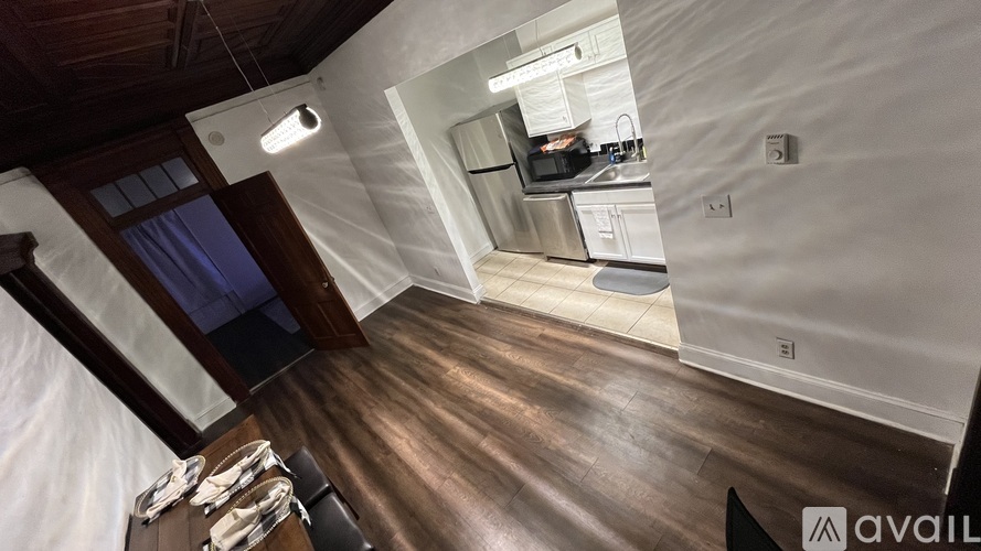 A kitchen with wooden floors and a stainless steel refrigerator.