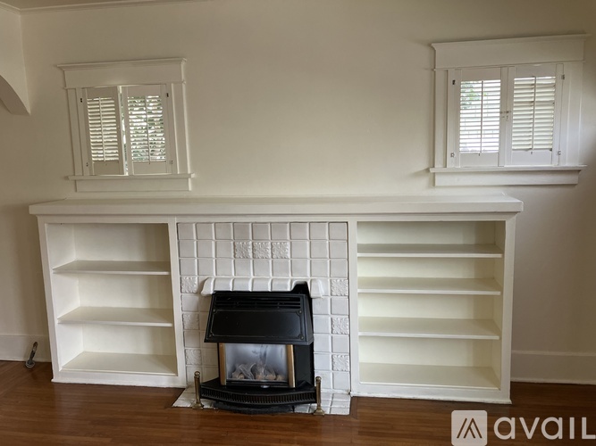 A fireplace with a black grate and a white mantle.