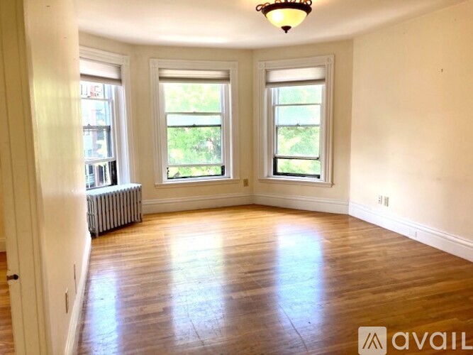 A room with wooden floors and two windows.