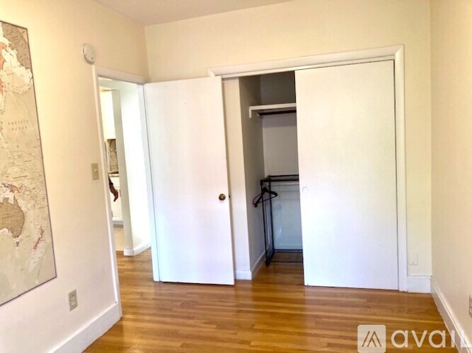 A room with a white door and a wooden floor.