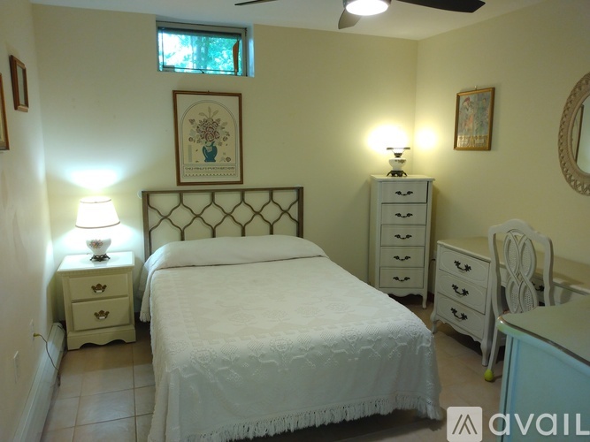 A bedroom with a bed, dresser, and mirror.