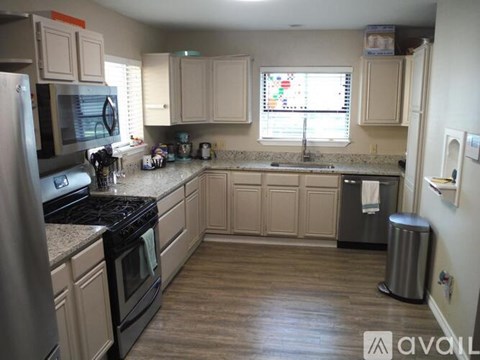A kitchen with wooden cabinets and a black stove top.