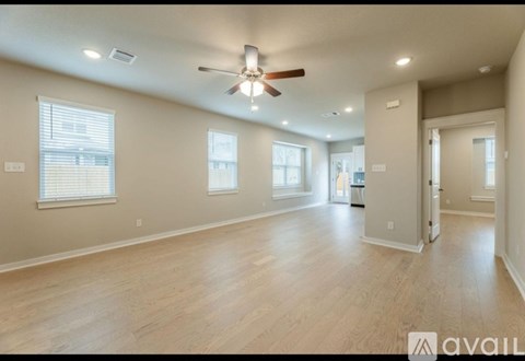 A spacious room with a ceiling fan and lighting fixtures.
