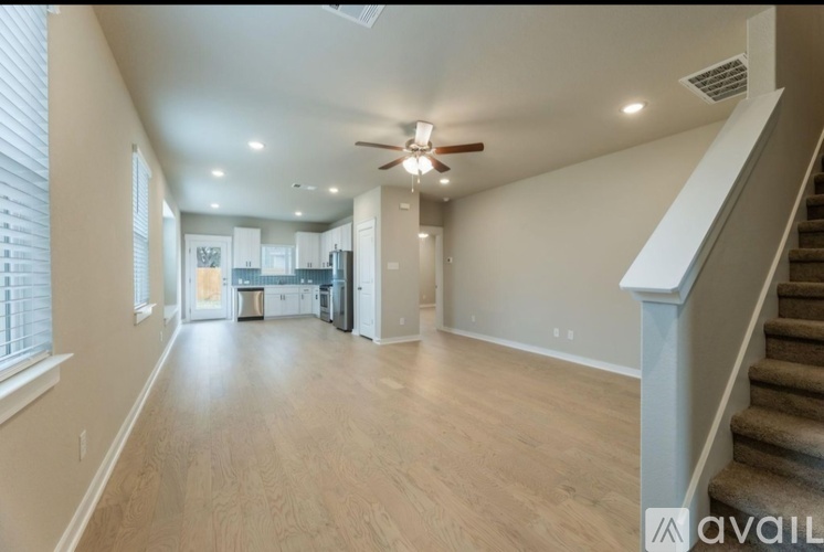 A spacious living room with a staircase on the right side.