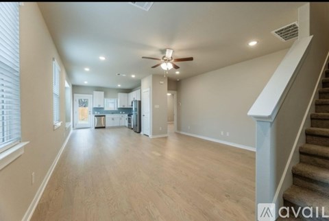 A spacious living room with a staircase on the right side.