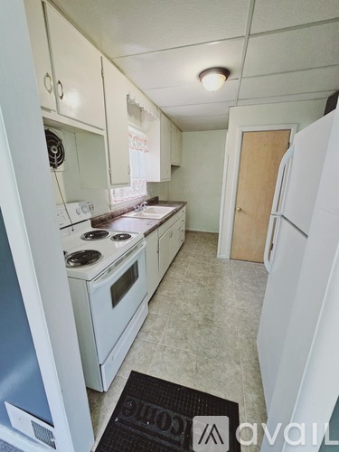 A kitchen with white appliances and cabinets.