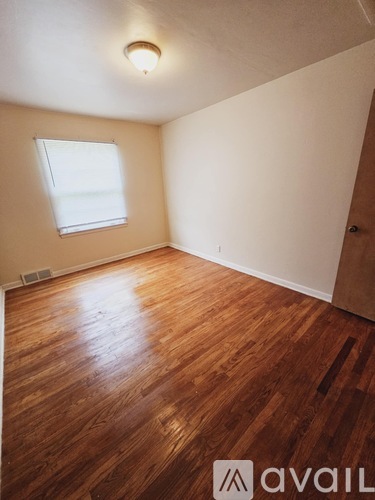 A room with wooden flooring and a window.