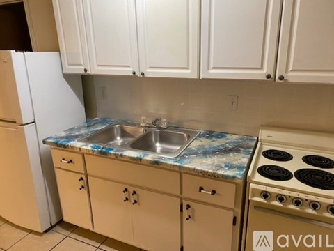 A kitchen with white cabinets and a granite countertop.