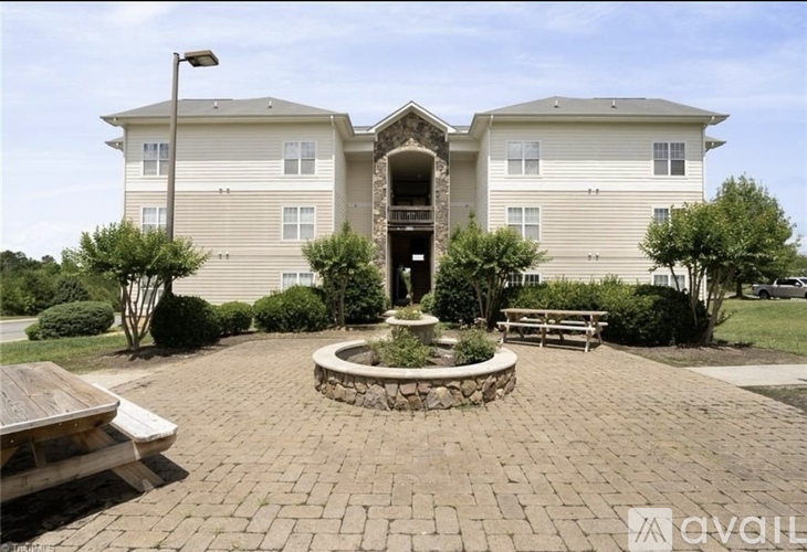 A brick courtyard in front of a two-story apartment building.