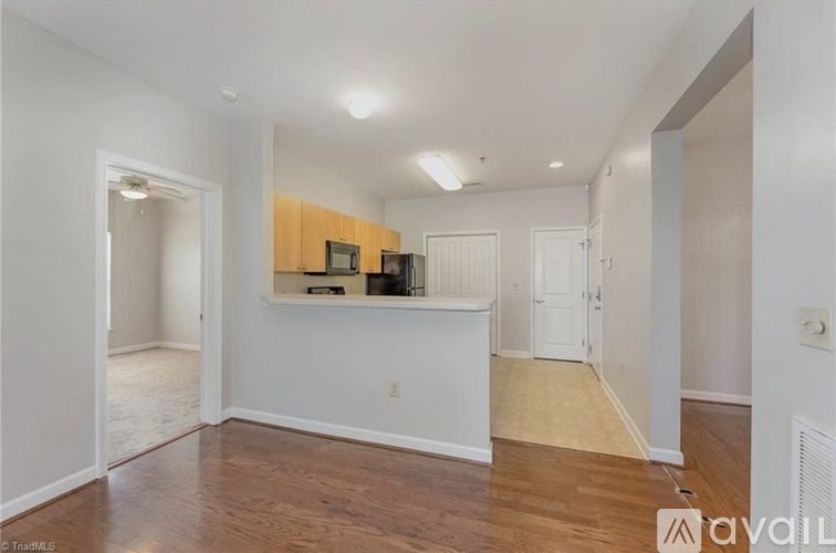 A spacious room with wooden flooring and white walls.